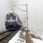 Baramulla: A train runs on a track as the surroundings are covered in snow on a cold winter morning in Baramulla on Friday, January 3, 2025. (Photo: IANS/Nisar Malik)