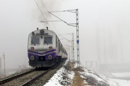 Baramulla: A train runs on a track as the surroundings are covered in snow on a cold winter morning in Baramulla on Friday, January 3, 2025. (Photo: IANS/Nisar Malik)